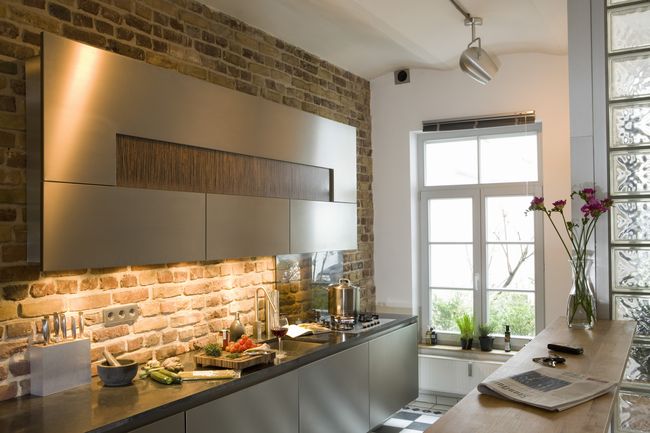 Если открытая кирпичная стена располагается в кухне, ее обязательно следует обработать специальными защитными составами